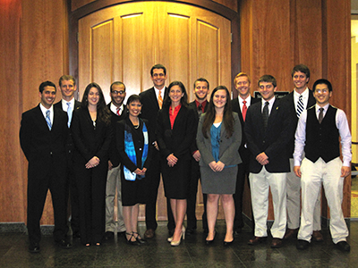 Large group of professionals in business attire in front of large interior door